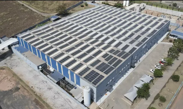 Vista aérea de uma unidade industrial em Rio Claro/SP, com módulos fotovoltaicos cobrindo todo o telhado do galpão