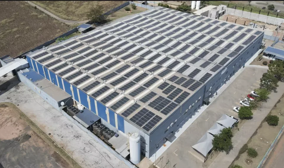 Vista aérea ampliada de uma unidade industrial em Rio Claro/SP, com módulos fotovoltaicos cobrindo todo o telhado